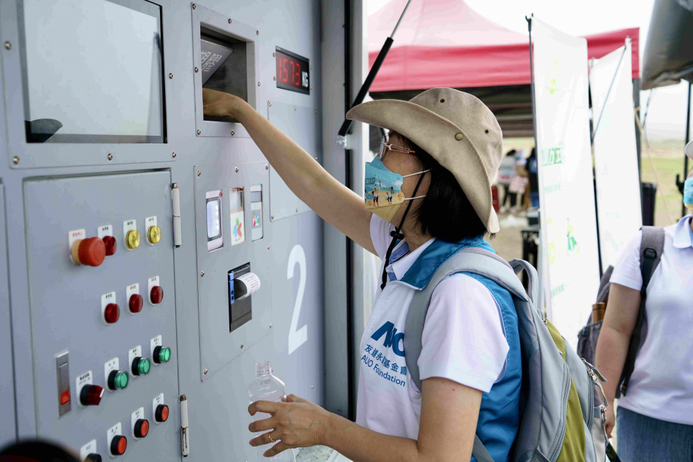 志工們將拾起的寶特瓶投入「好歸塑專車」，讓廢棄塑料空瓶可以直接粉碎、縮小體積，未來將可再製成購物袋、寶特衣、悠遊卡等生活用品